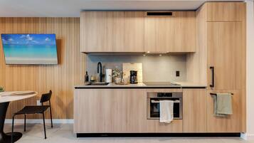 Eine moderne Küche mit Holzausstattung, einem eingebauten Backofen und einem Essbereich mit Tisch und Stühlen.