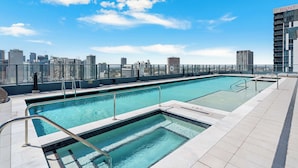 A rooftop swimming pool with a city skyline view, a glass railing, and a clear sky. - Aura Studio, Heart of Miami With Resort Amenities (Miami)