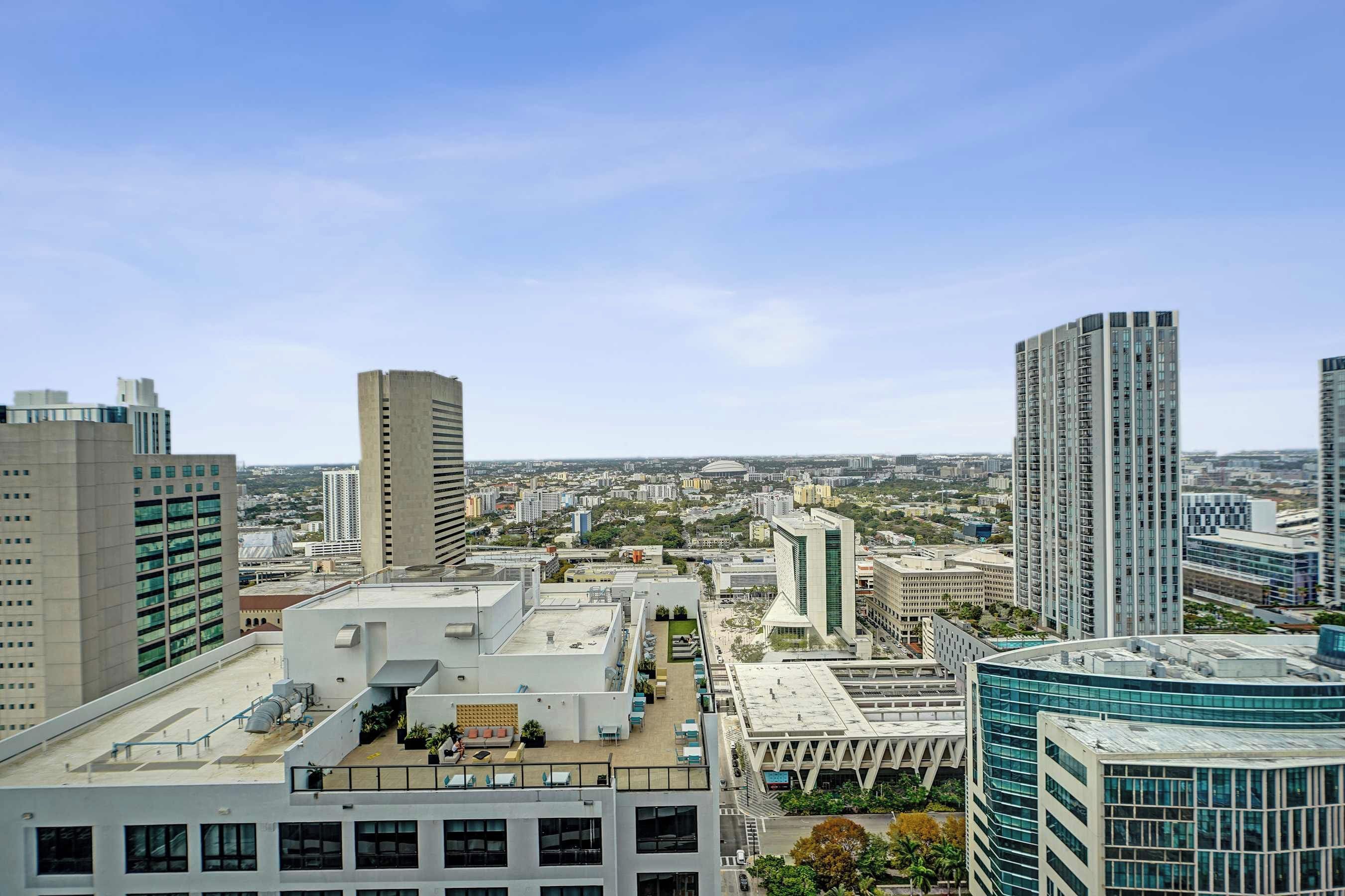 A high-rise building with a rooftop terrace, large windows, and a modern architectural design.