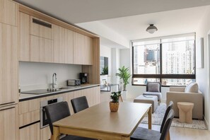 A modern kitchen with a dining area, large windows, and a view of the city. - City Dreams Sauna, Rooftop Pool & Parking (Miami)