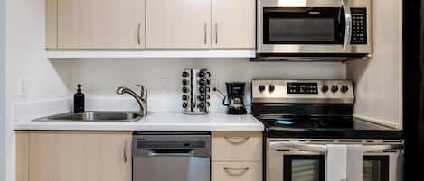 A modern kitchen with stainless steel appliances, including a microwave, stove, and dishwasher.