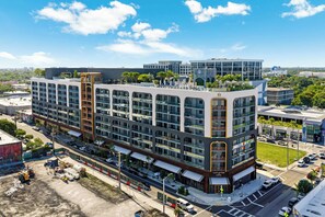 A multi-story hotel with a modern design, featuring a rooftop terrace and a ground-level restaurant. - Wynwood Pad- Stylish Apt With View & Rooftop Pool (Miami)