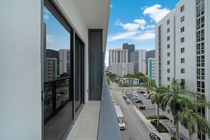 A high-rise building with large windows, a clear view of the street below, and other buildings in the background. - Brickell Skyline Pool, Gym, and Central Location (Miami)