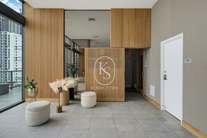 A modern spa interior with a reception desk, wooden paneling, and a view of the cityscape. - Brickell Skyline Pool, Gym, and Central Location (Miami)