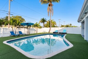 A swimming pool with artificial grass, a white fence, and palm trees. - Ivory House Private Retreat With Pool Near Beach (Hollywood)