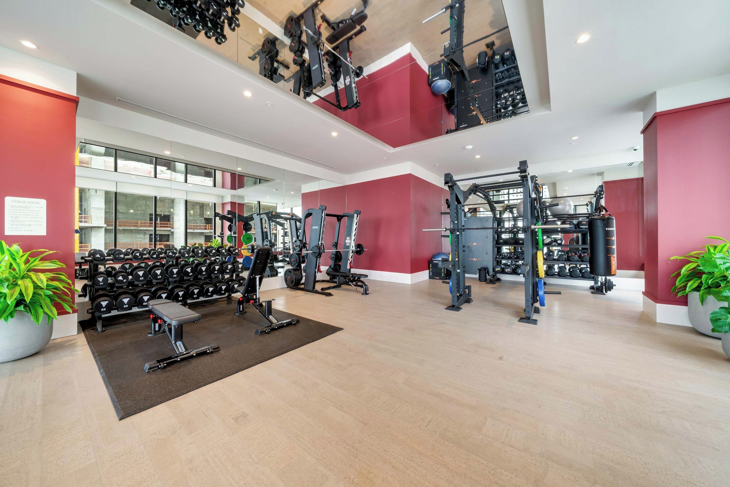 A gym with weightlifting equipment, treadmills, and dumbbells.