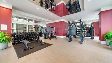 A gym with weightlifting equipment, treadmills, and dumbbells.