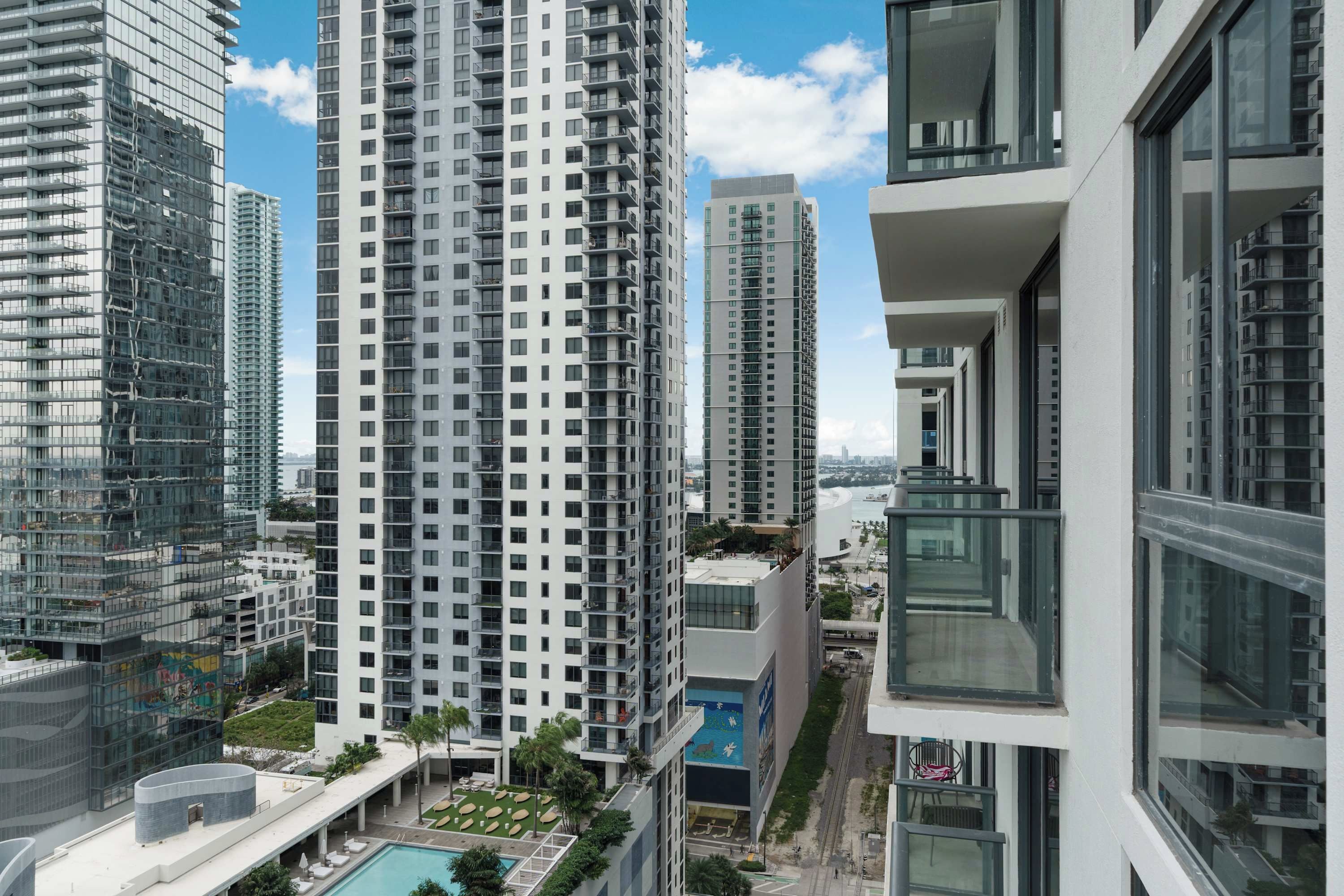 A high-rise building with multiple balconies and a pool area.