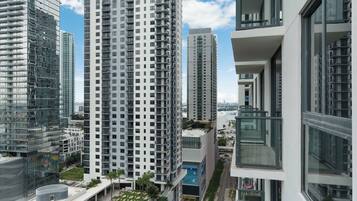 A high-rise building with multiple balconies and a pool area.