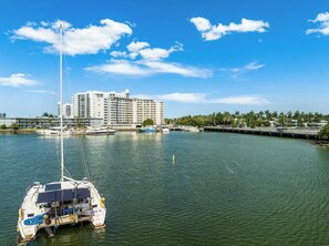 A marina with boats, a large building in the background, and a clear sky.