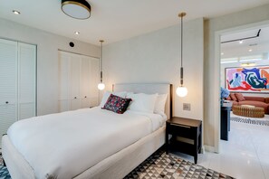 A modern bedroom with a large bed, bedside tables, and a geometric-patterned rug. - Casa Anton Artist Home, Pool & Rooftop Terrace (Miami)