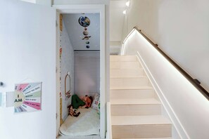 A staircase with a handrail and a wall with a 'I AM' poster.
