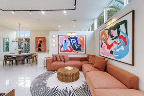 A modern living room with a sectional sofa, a round coffee table, and abstract art on the walls.