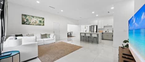 A modern apartment with a living room, kitchen, and dining area.