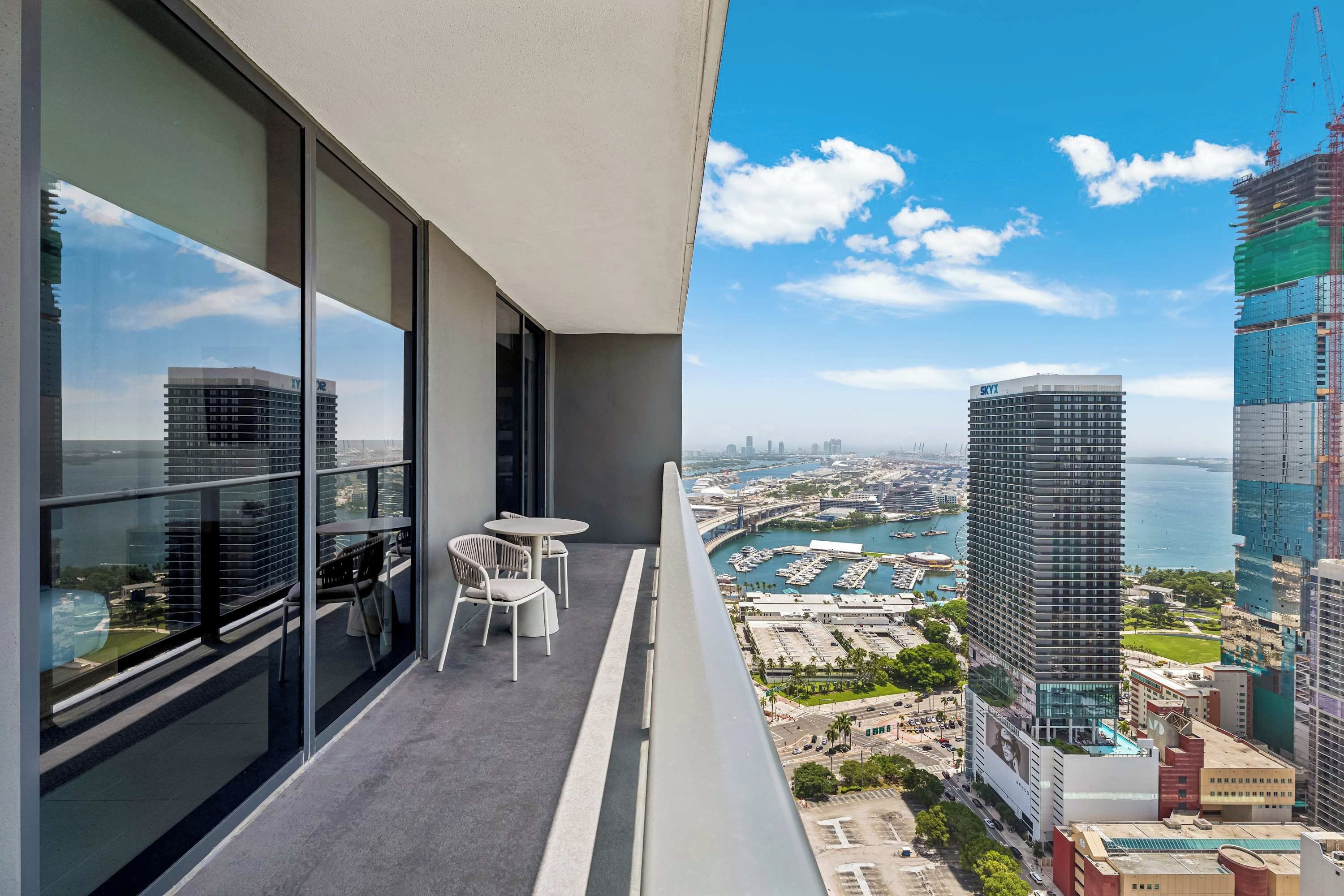 A balcony with a view of a cityscape, including a marina and high-rise buildings.