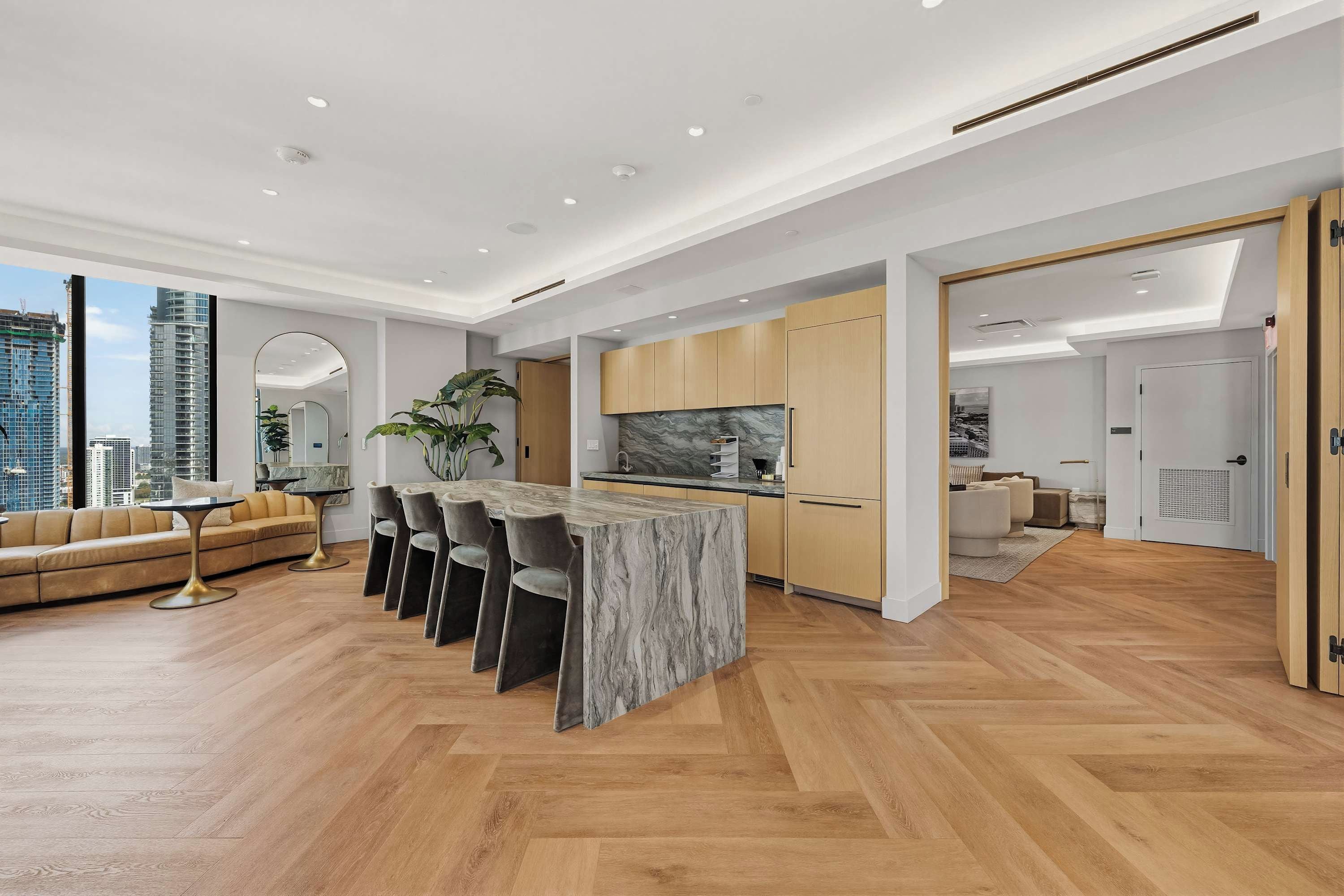 A modern interior with a kitchen island, dining area, and a sofa.