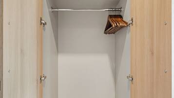 Ein begehbarer Kleiderschrank mit Regalen, einer Kleiderstange und einem gefalteten Handtuch.