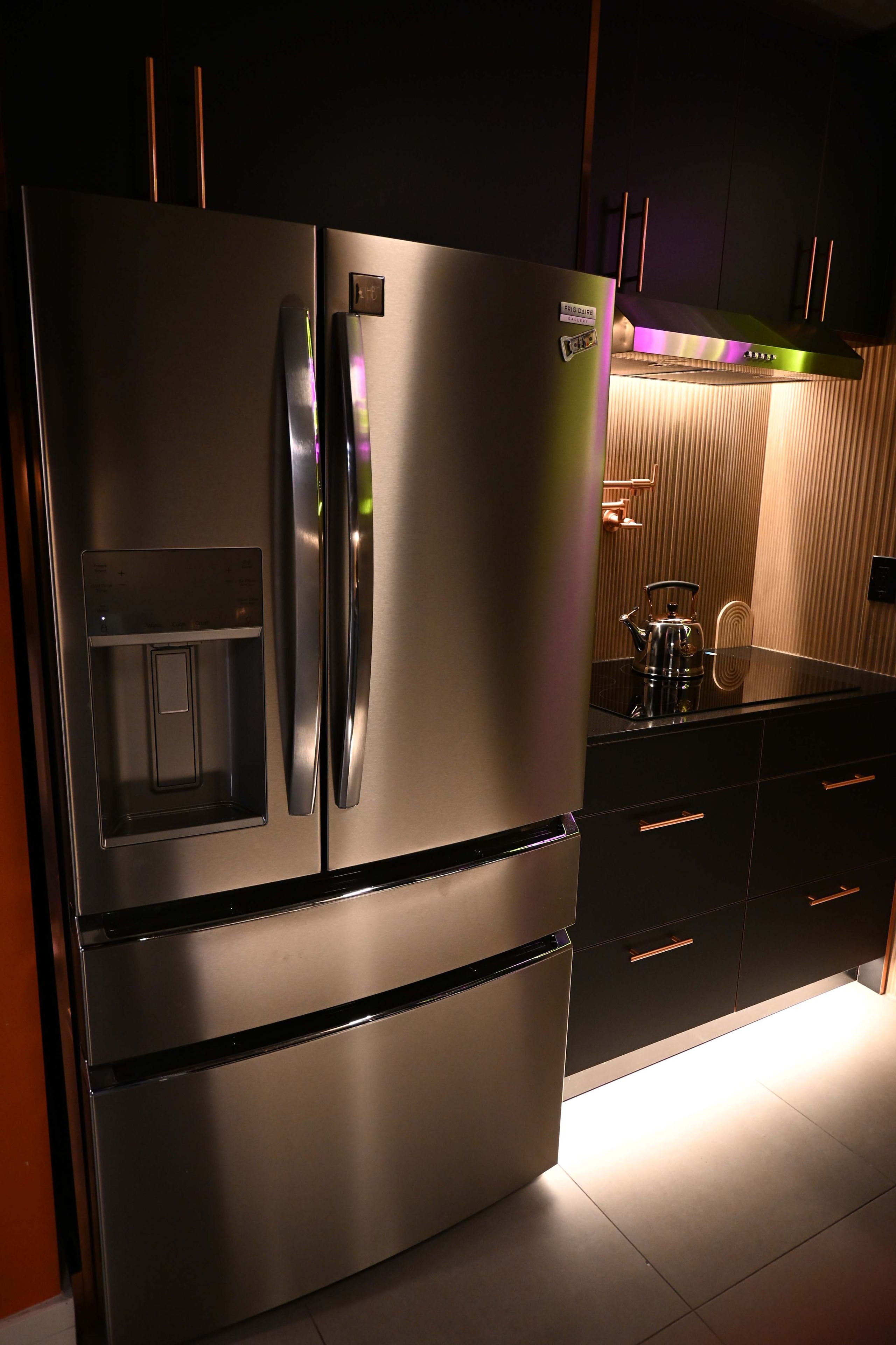 A stainless steel refrigerator with a water dispenser, a built-in oven, and a microwave.
