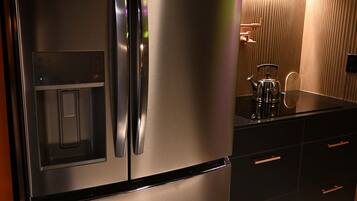 A stainless steel refrigerator with a water dispenser, a built-in oven, and a microwave.