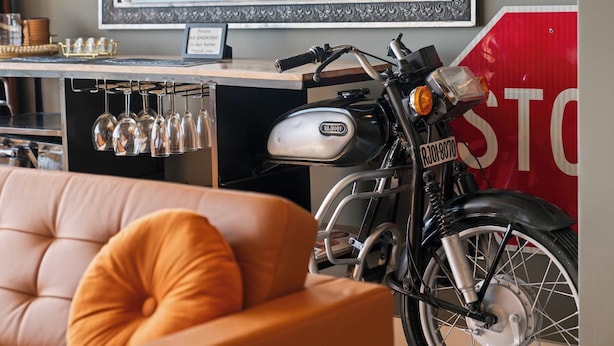 A motorcycle parked in a room with a stop sign, a couch, and a bar area with glasses. - Hollywood Beach Speakeasy Condo With Pool (Hollywood)