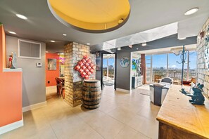 Amplia habitación con un ventanal grande, barra de madera y pared de piedra.