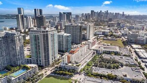 A high-rise urban area with modern buildings, a waterfront, and a mix of residential and commercial structures. - Midtown Rouge- Condo With City Views, Pool & Gym (Miami)