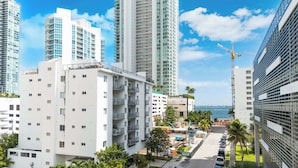 A high-rise residential building with balconies, a parking area, and a view of the sea. - Edgewater Pad- Balcony, Parking and Prime Location (Miami)