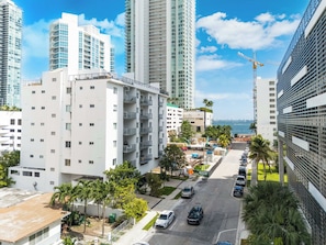 Un palazzo residenziale alto con balconi, un'area di parcheggio e vista sul mare.