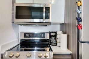 Una cocina con un microondas, estufa y refrigerador de acero inoxidable.