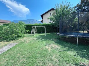 A backyard with a trampoline, a swing set, and a ladder. - Maison 8p. Aix-les-Bains Piscine (Aix-les-Bains)