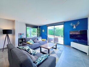 Ein modernes Wohnzimmer mit einer Couch, einem Couchtisch und einem Fernseher.