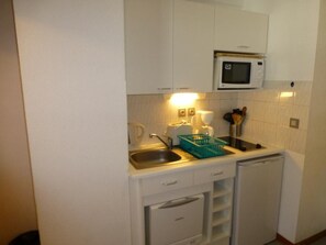 A compact kitchenette with a microwave, sink, and storage cabinets. - 200m from ski lifts, 4th floor, balcony, tv, 23m², Brides Les Bains (Brides-les-Bains)