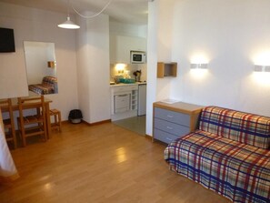 A compact living space with a kitchenette, a dining area, and a sofa. - 200m from ski lifts, 4th floor, balcony, tv, 23m², Brides Les Bains (Brides-les-Bains)