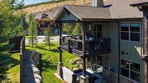 A two-story house with a balcony, a stone retaining wall, and a small swimming pool. - High West Hideaway by Avantstay Mountain-view Townhome Hot Tub + Firepit Near Park City (Heber City)