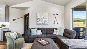 A modern living room with a sectional sofa, a small side table, and a view of the outdoors. - High West Hideaway by Avantstay Mountain-view Townhome Hot Tub + Firepit Near Park City (Heber City)