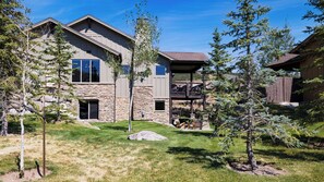 A residential building with a stone facade, a covered patio area, and a well-maintained lawn. - High West Hideaway by Avantstay Mountain-view Townhome Hot Tub + Firepit Near Park City (Heber City)