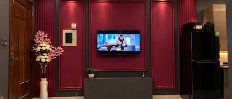 A modern living room with a flat-screen TV, a ceiling fan, and a marble coffee table.