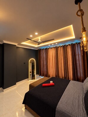A modern bedroom with a bed, a ceiling fan, recessed lighting, and a curtain.