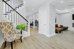 A modern interior with a staircase, a dining area, and a seating area with sofas. - 4BR, 3.5 Baths · Spa Tub · Near Downtown Columbus (Columbus)