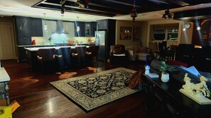 Una cocina moderna con armarios oscuros, una isla central e iluminación colgante.