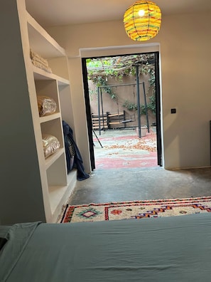 An interior space with a doorway leading to an outdoor area with a swing set and a patterned rug.