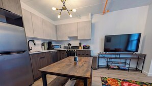 A modern kitchen with a central island, built-in appliances, and a flat-screen TV. - 1 Bdrm Gem: Walkable, Downtown, Queen Bed (Detroit)
