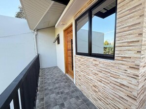 A modern exterior with a wooden door, a window, and a tiled floor. - Casa Apollo Suites (Puerto Princesa City)