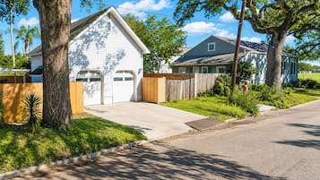 A residential street with houses, a driveway, and a sidewalk.