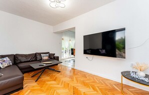 A modern living room with a sofa, coffee table, and a flat-screen TV mounted on the wall. - Gorgeous home in Pridraga with private swimming pool, can be inside or outside (Pridraga)