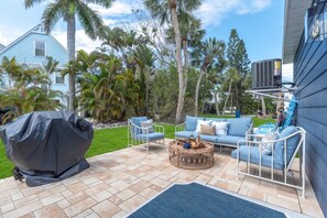 Une terrasse avec mobilier d’extérieur, un barbecue et une piscine.