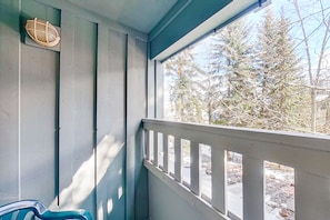 A balcony with a view of trees and a stone pathway.
