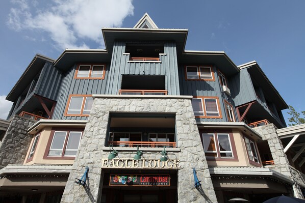 A multi-story building with a stone facade and a sign reading 'EAGLE LODGE.'