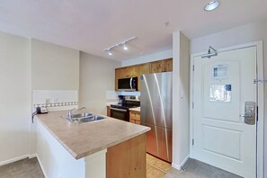 Eine moderne Küche mit einem Edelstahl-Kühlschrank, Holzschränken und einer eingebauten Mikrowelle.