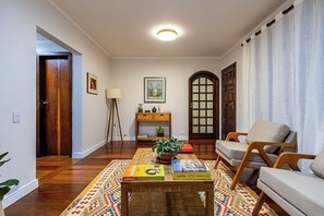 A living room with a wooden coffee table, a sofa, a lamp, and a bookshelf.